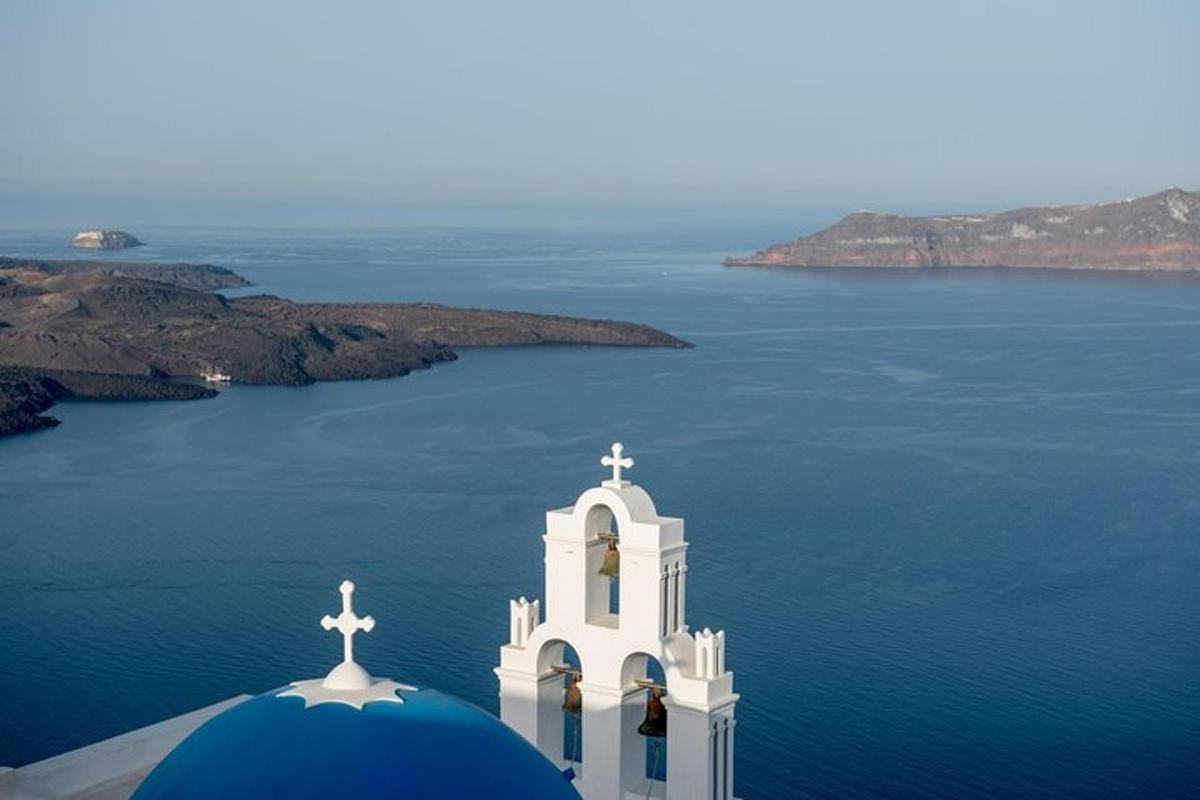 μια λευκή εκκλησία με έναν σταυρό πάνω από το νερό