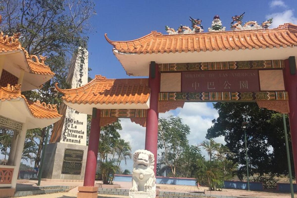 um portão com uma estátua em frente a um prédio