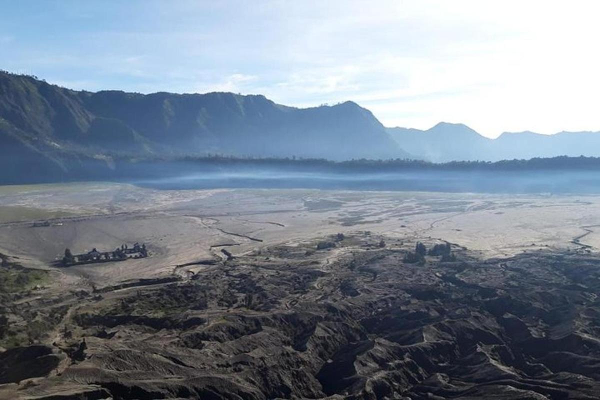 an aerial view of a lake with mountains in the background