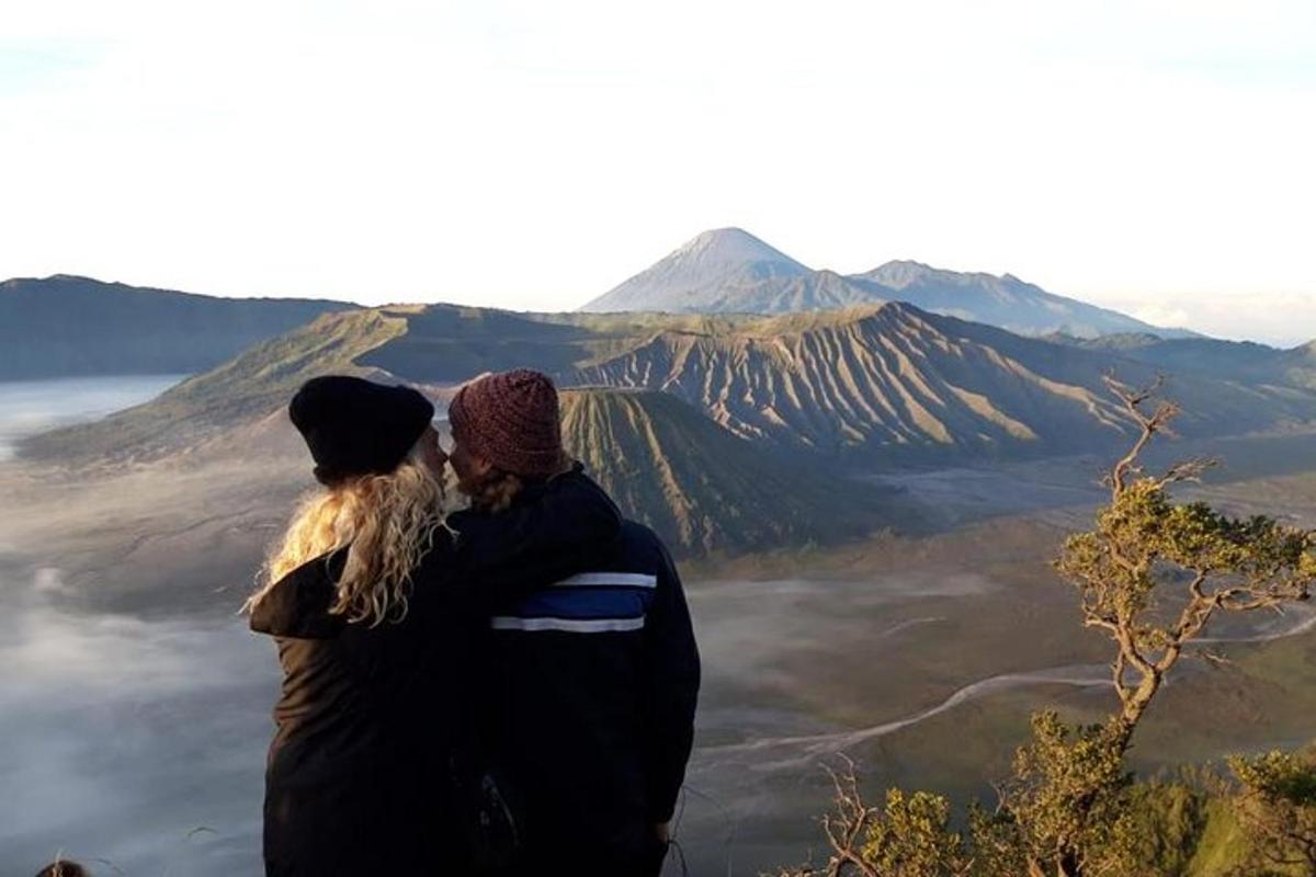 a man and woman standing on top of a mountain