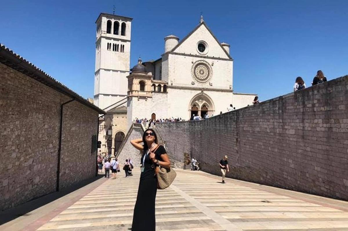 una donna in piedi davanti a un edificio con una torre dell'orologio