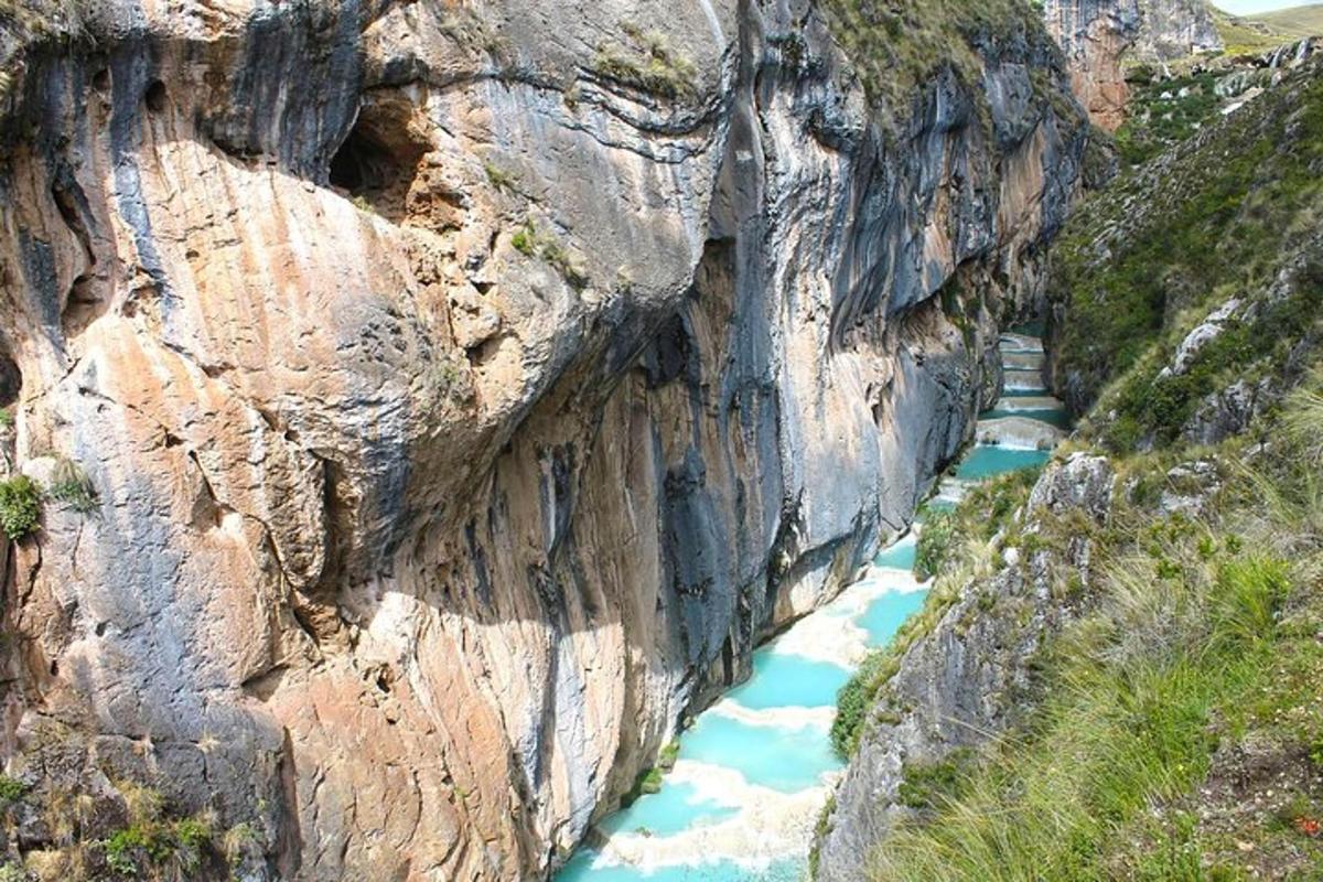 a river cuts through a rocky mountain cliff