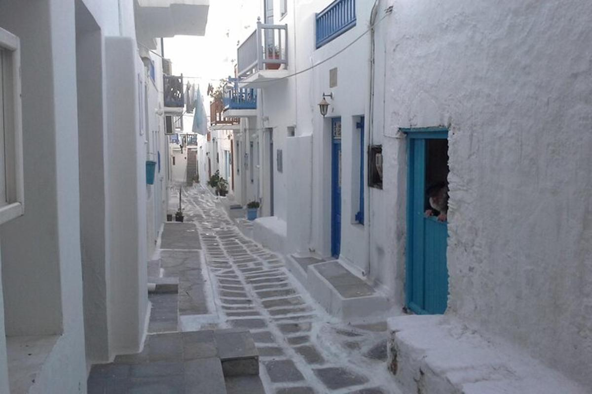 un carreró estret amb edificis blancs i una porta blava
