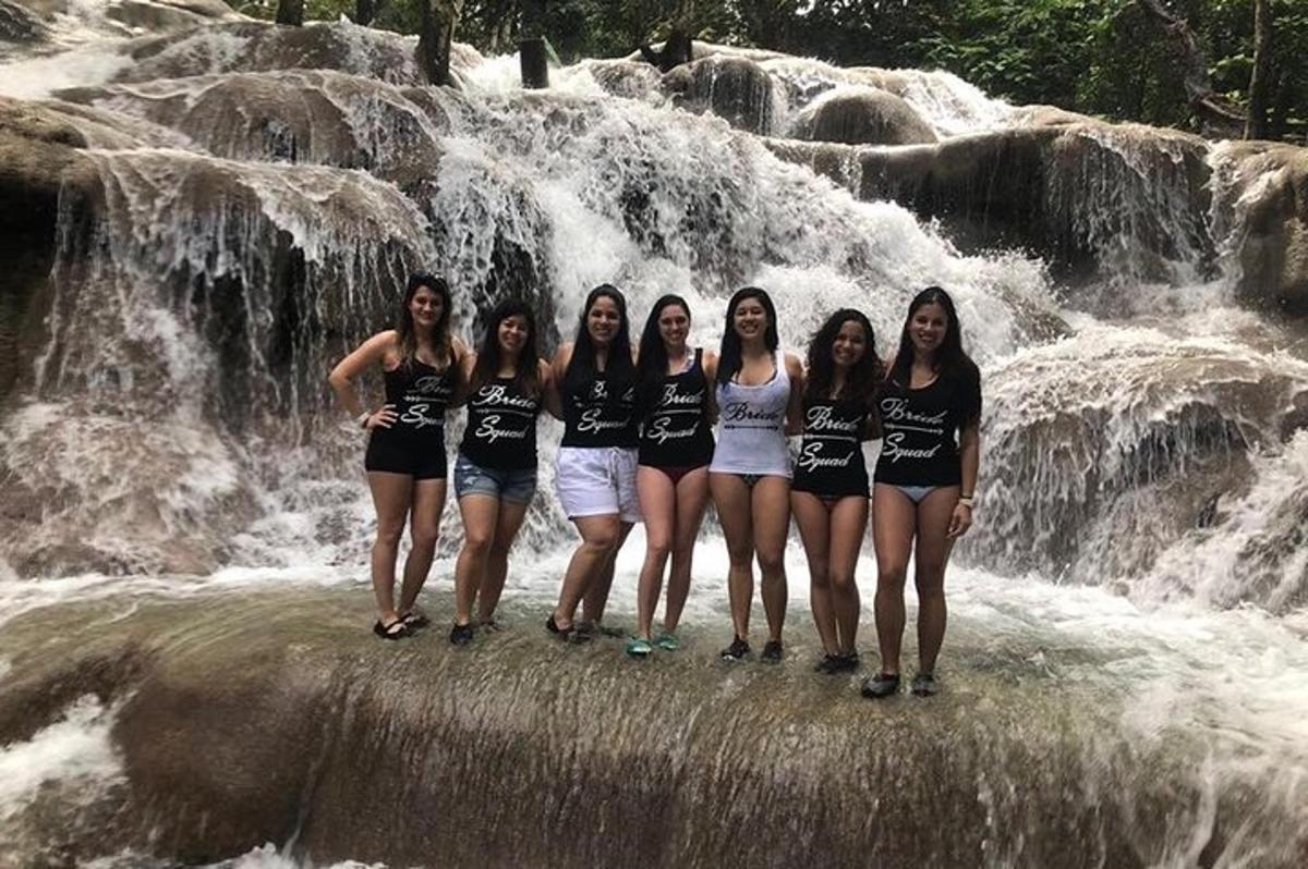 sekelompok wanita berdiri di depan air terjun