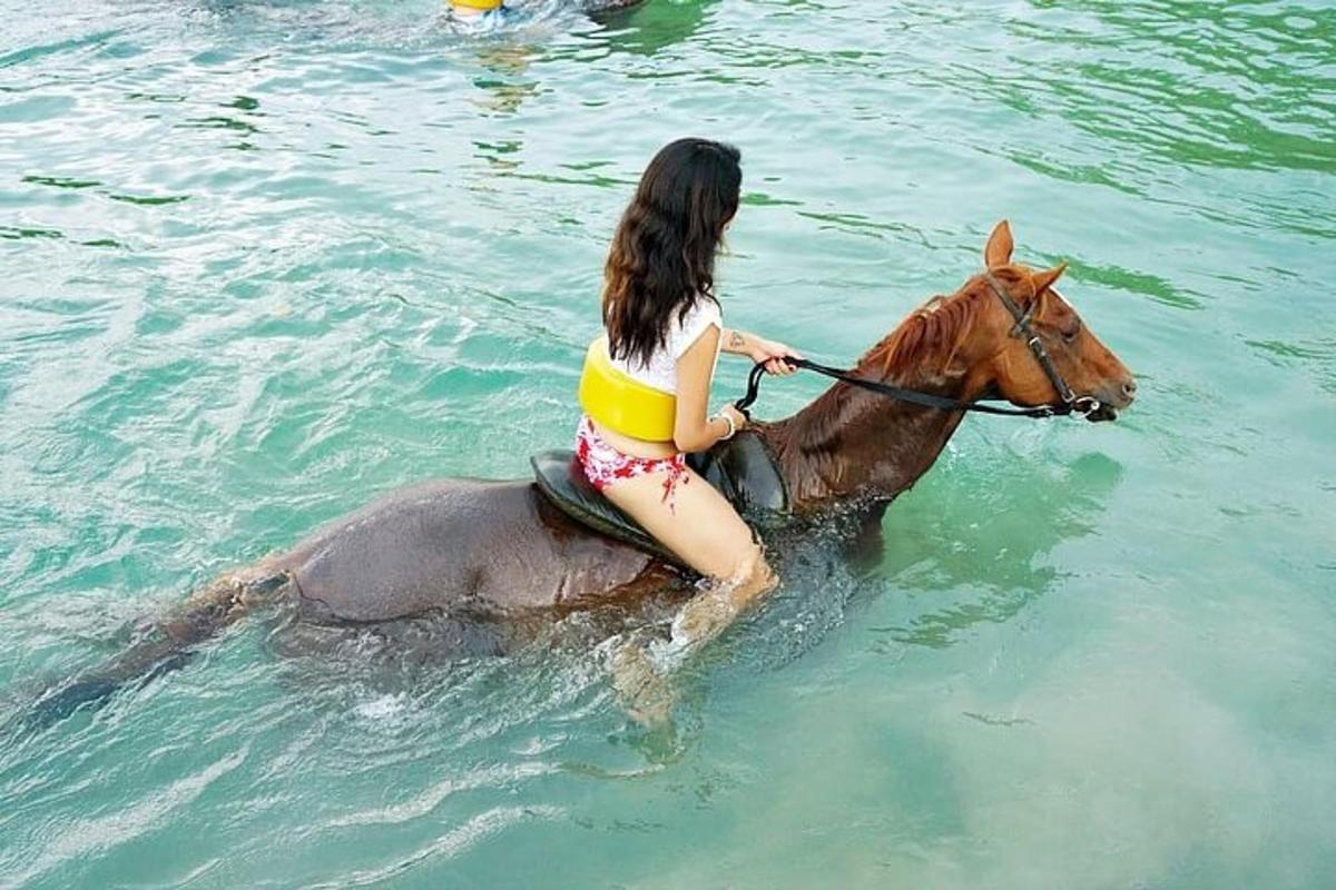 žena jedoucí na koni ve vodě