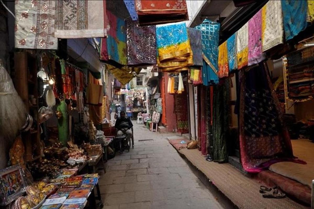 eine Gasse mit einer Person, die auf einem Stuhl auf einem Markt sitzt