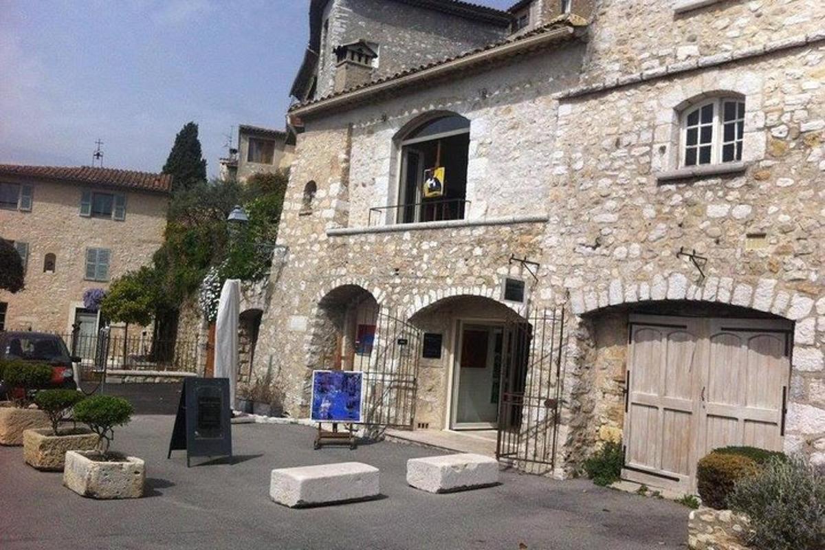 ένα κτίριο με έναν σκύλο να βγάζει το κεφάλι του από ένα παράθυρο