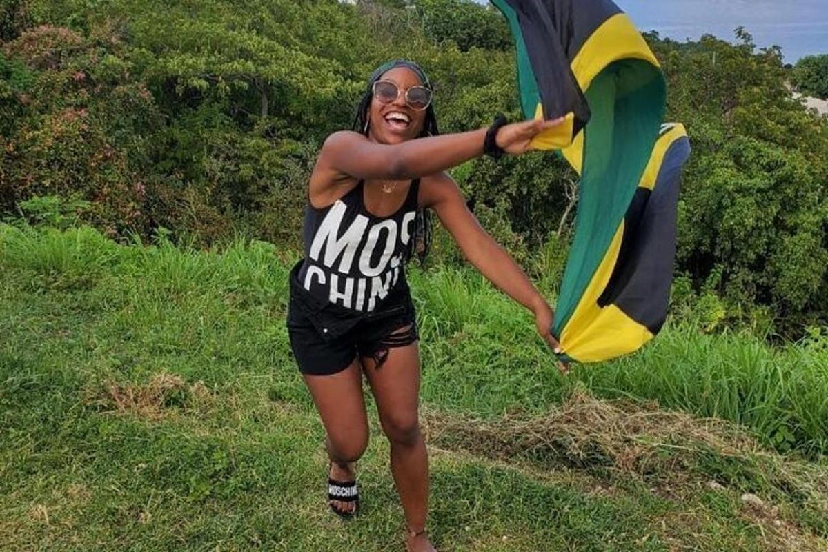 uma mulher parada em um campo segurando uma pipa