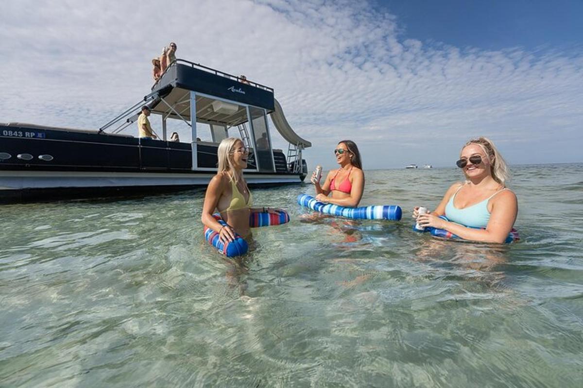 tre donne sedute in acqua davanti a una barca