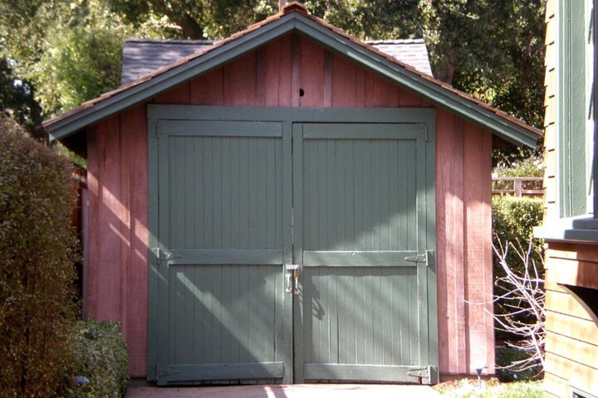 a red shed with a green garage door