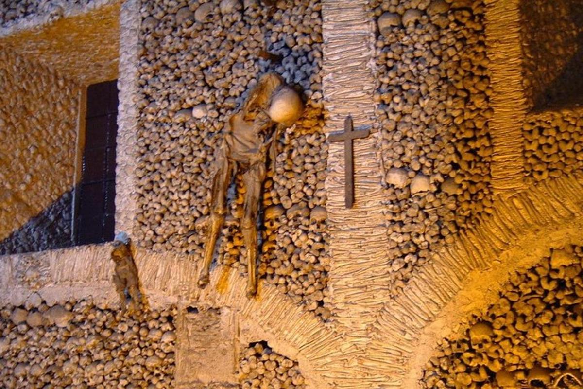 socha muže s křížem na budově