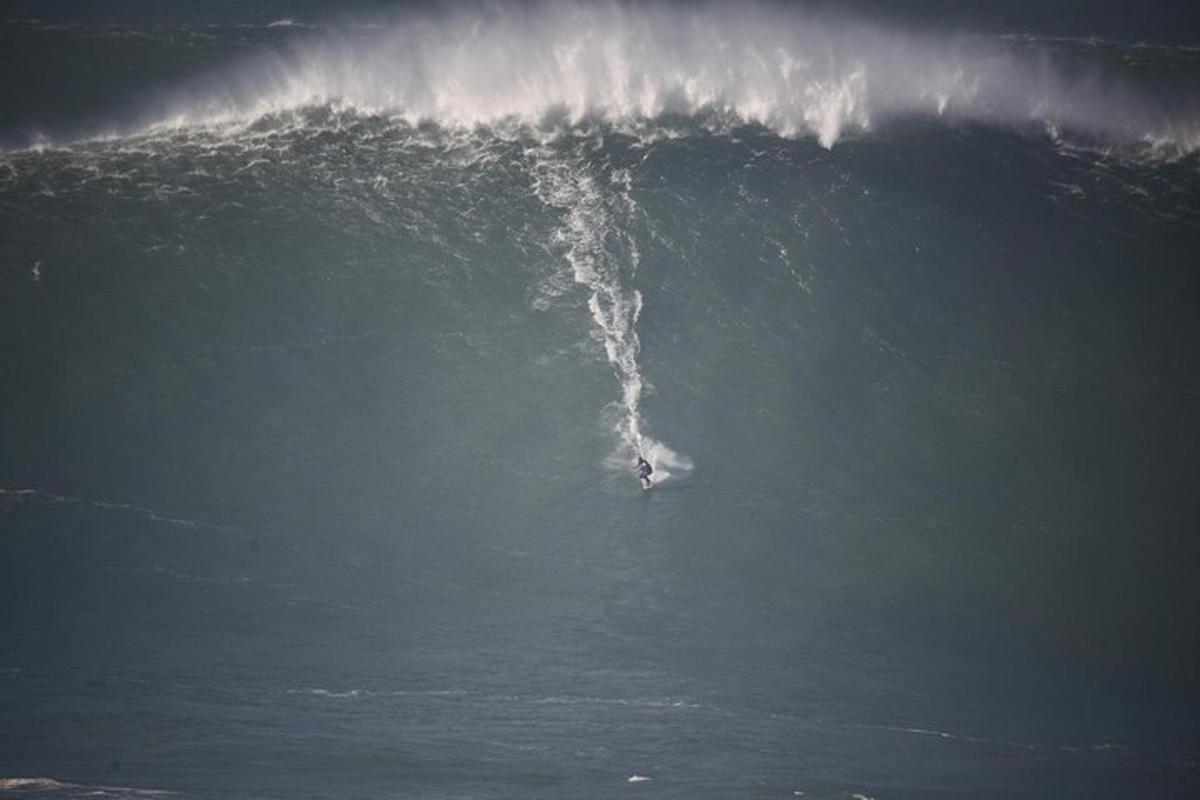 una persona che cavalca una grande onda nell'oceano