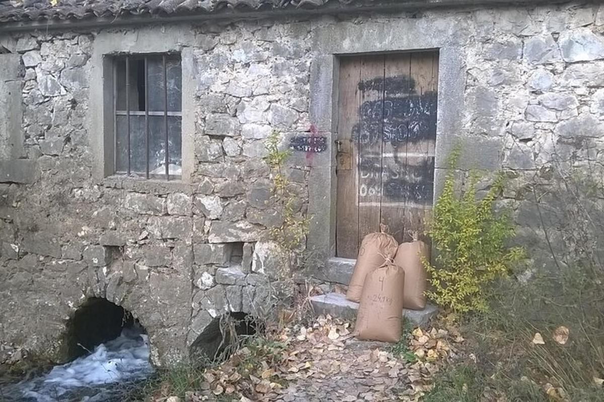 un vecchio edificio in pietra con due vasi davanti a una porta