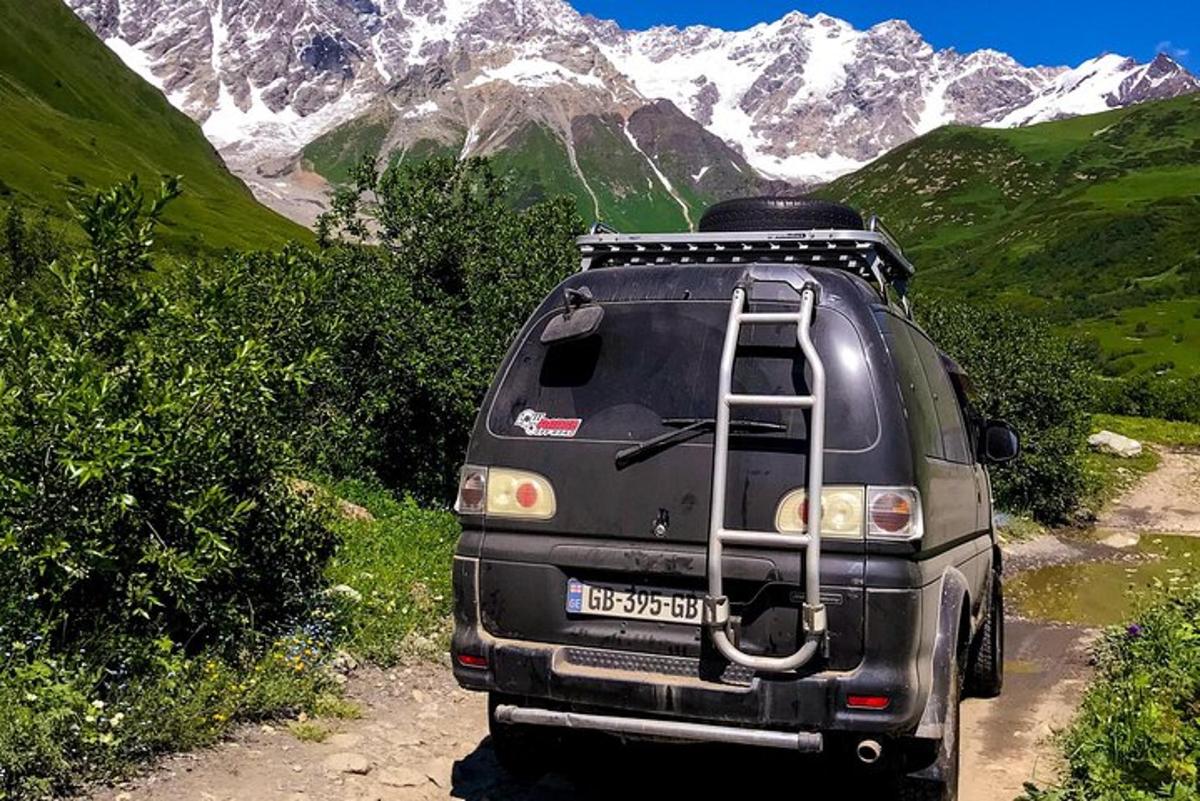 un furgone parcheggiato su una strada sterrata con le montagne sullo sfondo
