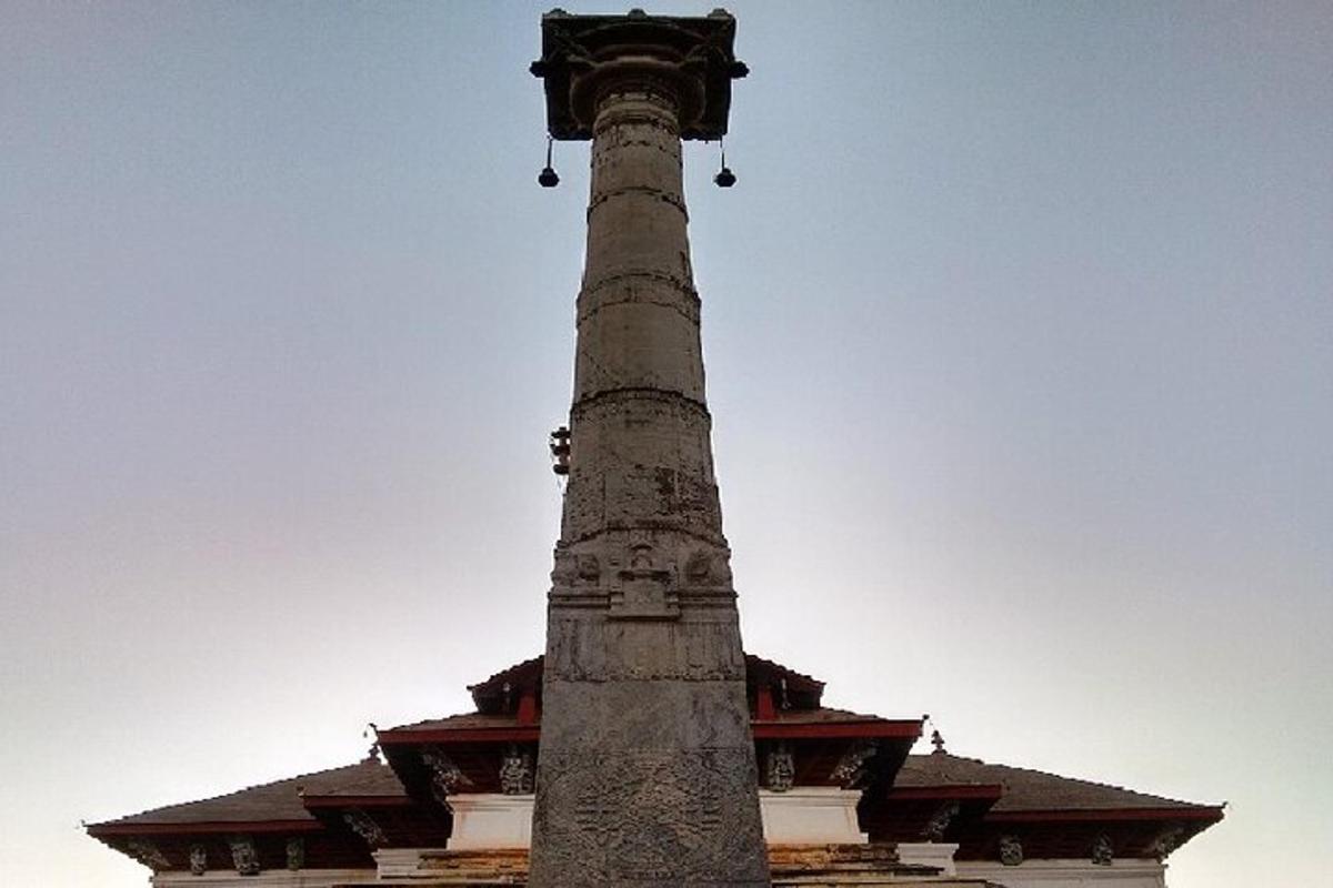 a tall stone pole in front of a building