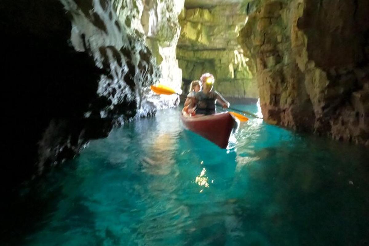 a couple of people in a kayak in a cave