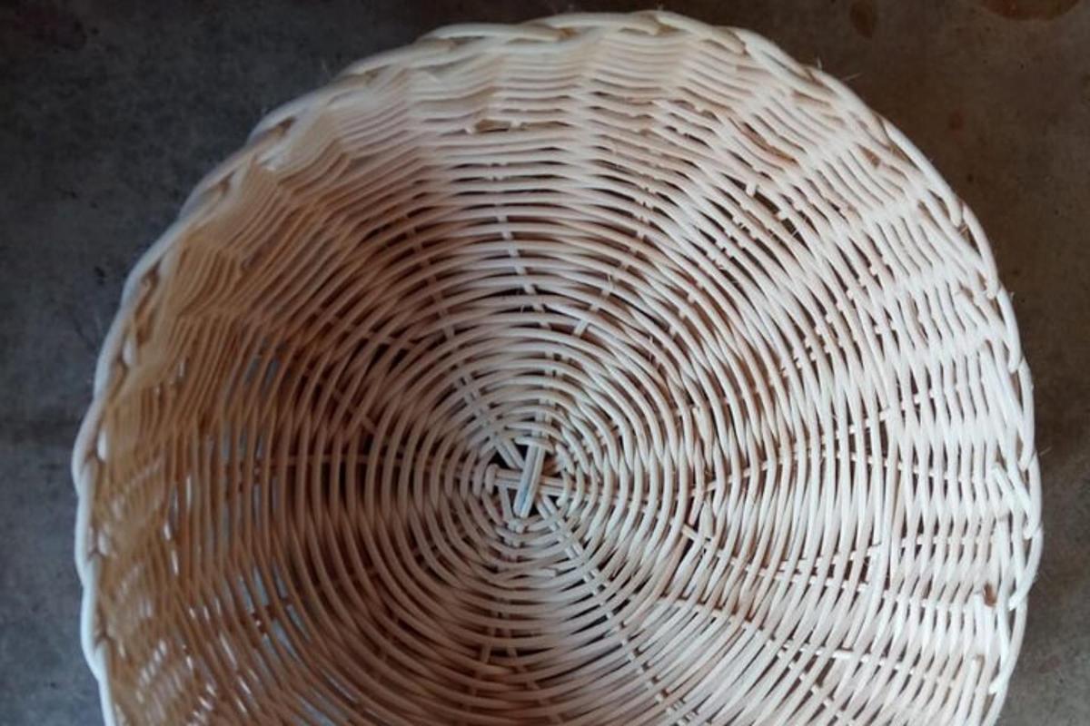a white wicker bowl sitting on top of a table