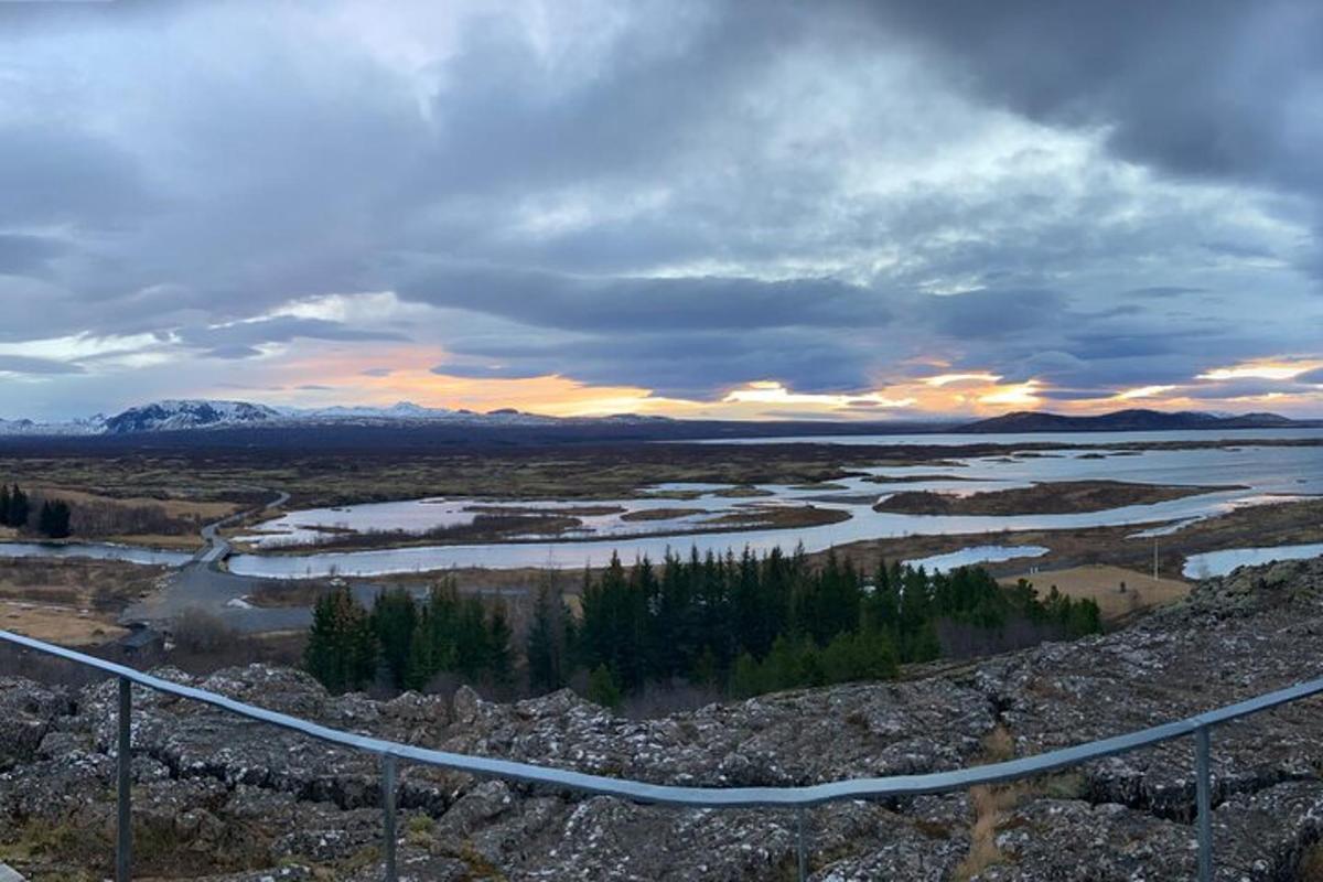 ein Blick auf einen Fluss bei Sonnenuntergang mit einem Zaun