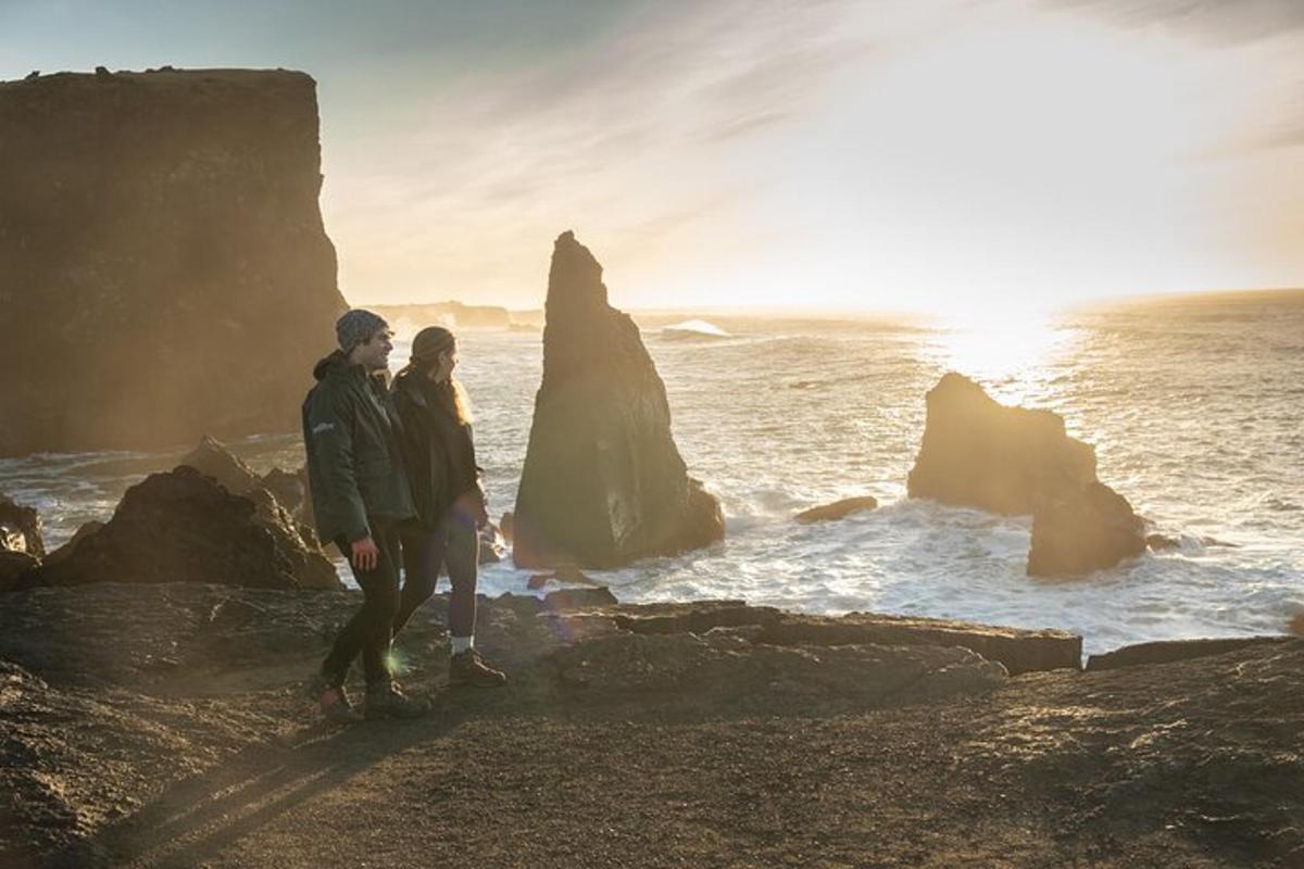 un cuplu stând pe stâncile de lângă ocean