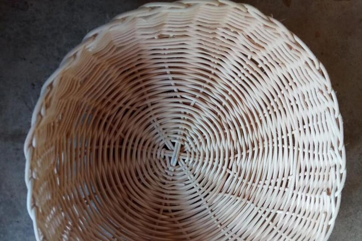 a white wicker bowl sitting on top of a table