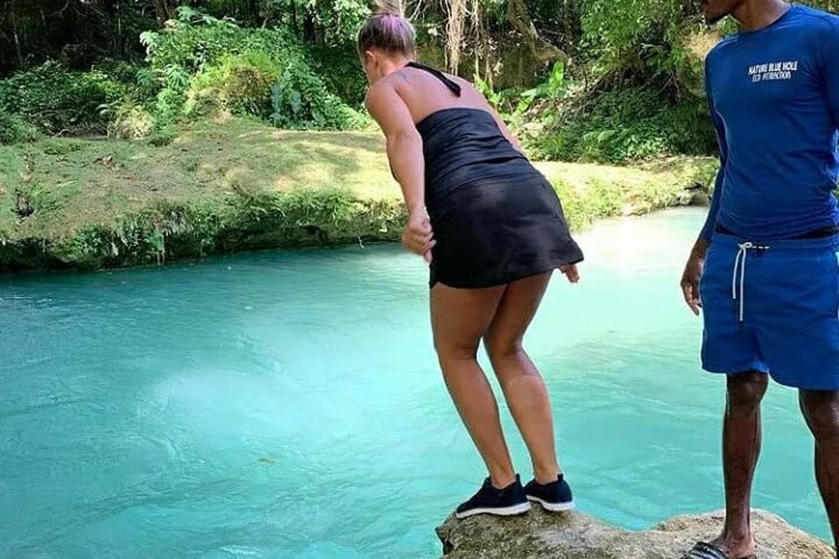 Dos personas de pie sobre una roca cerca de un río