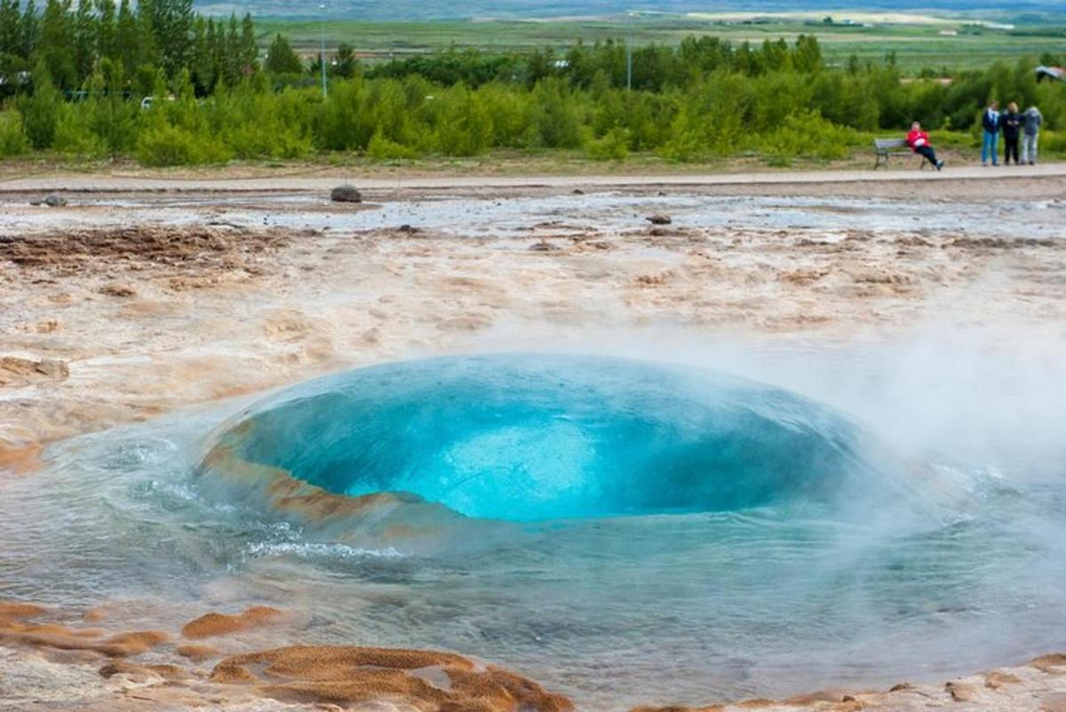 Un charco de agua azul en medio de un campo