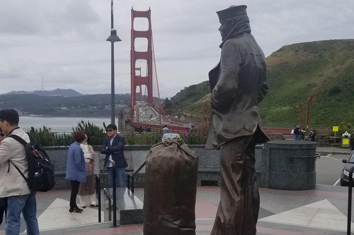 egy férfi szobra, aki a Golden Gate híd előtt áll