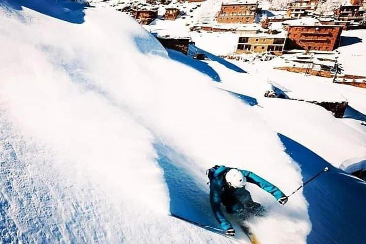 un uomo sta sciando lungo un pendio innevato