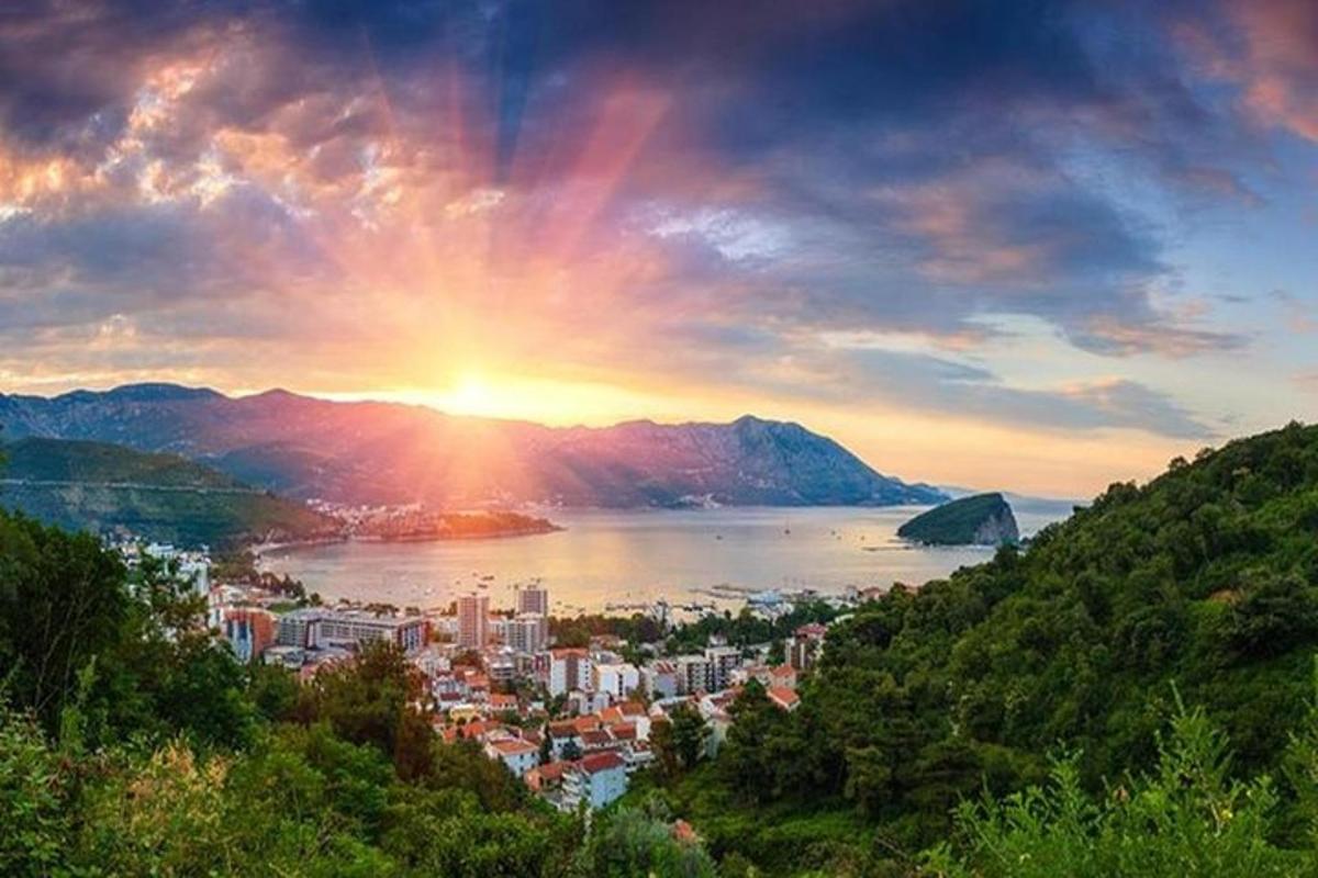 una vista d'una ciutat amb la posta de sol sobre l'aigua
