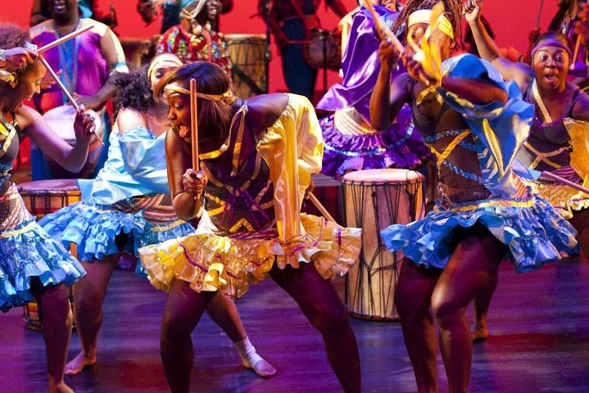 a group of women in dresses dancing on a stage