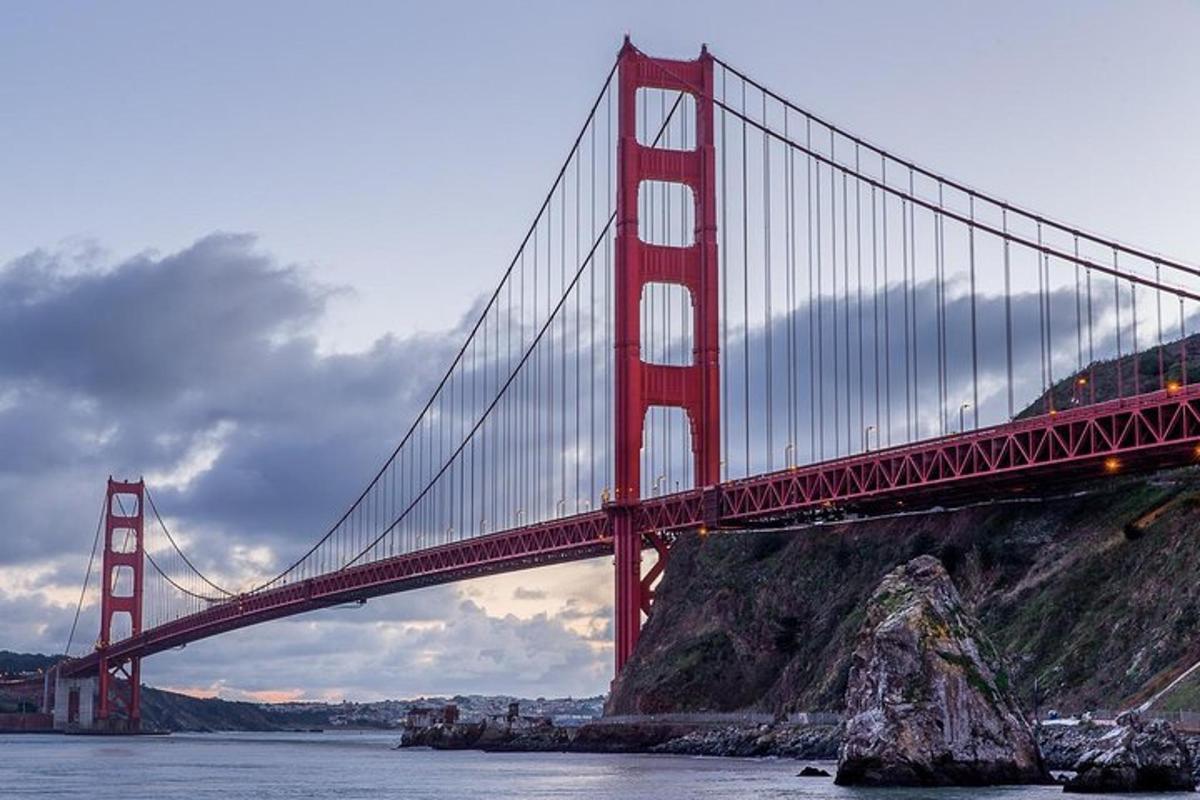 Un puente rojo sobre el agua al lado de una montaña.