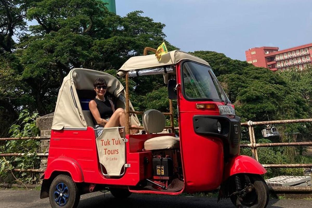 Un hombre sentado en un pequeño carrito de golf rojo.