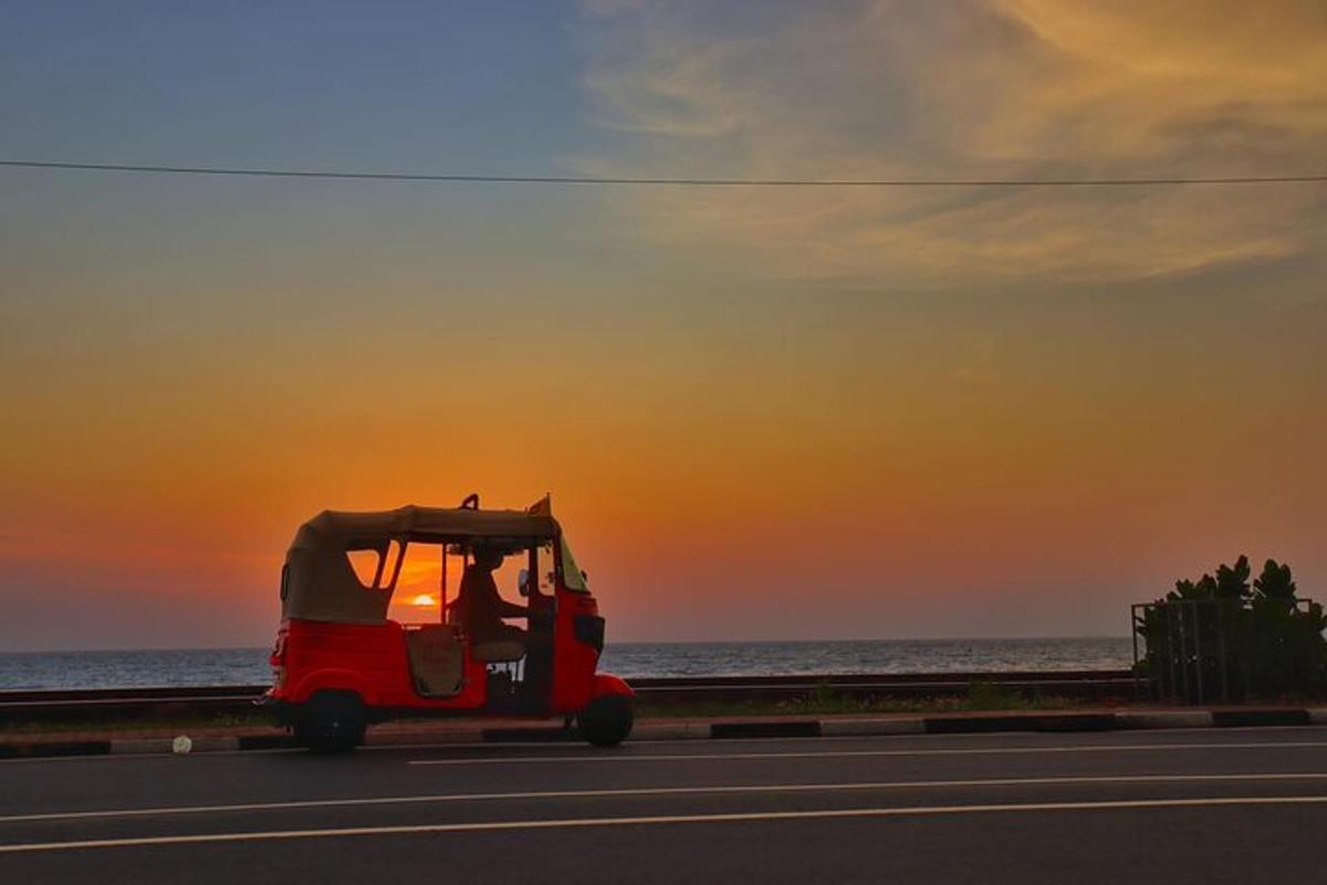 Un carrito de golf rojo circulando por una carretera al atardecer.