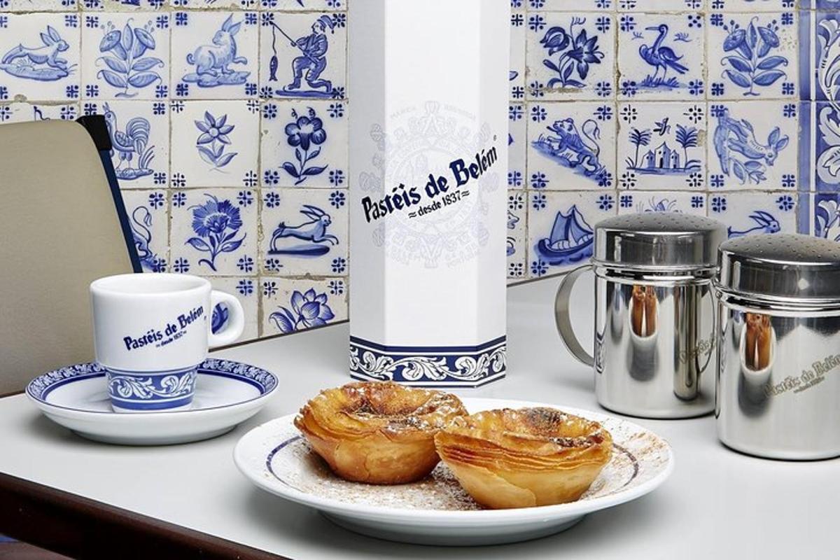 Una mesa con un plato de pasteles y una taza de café.