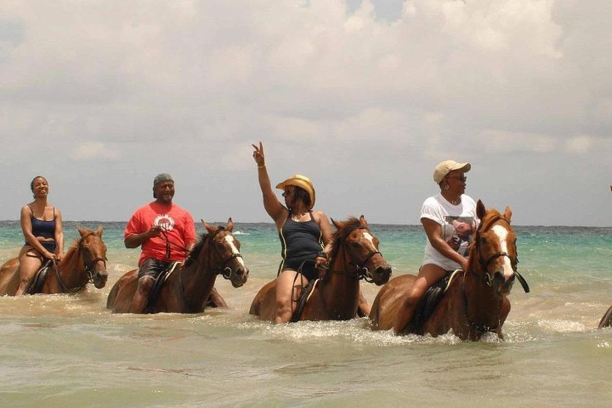 um grupo de pessoas andando a cavalo na praia