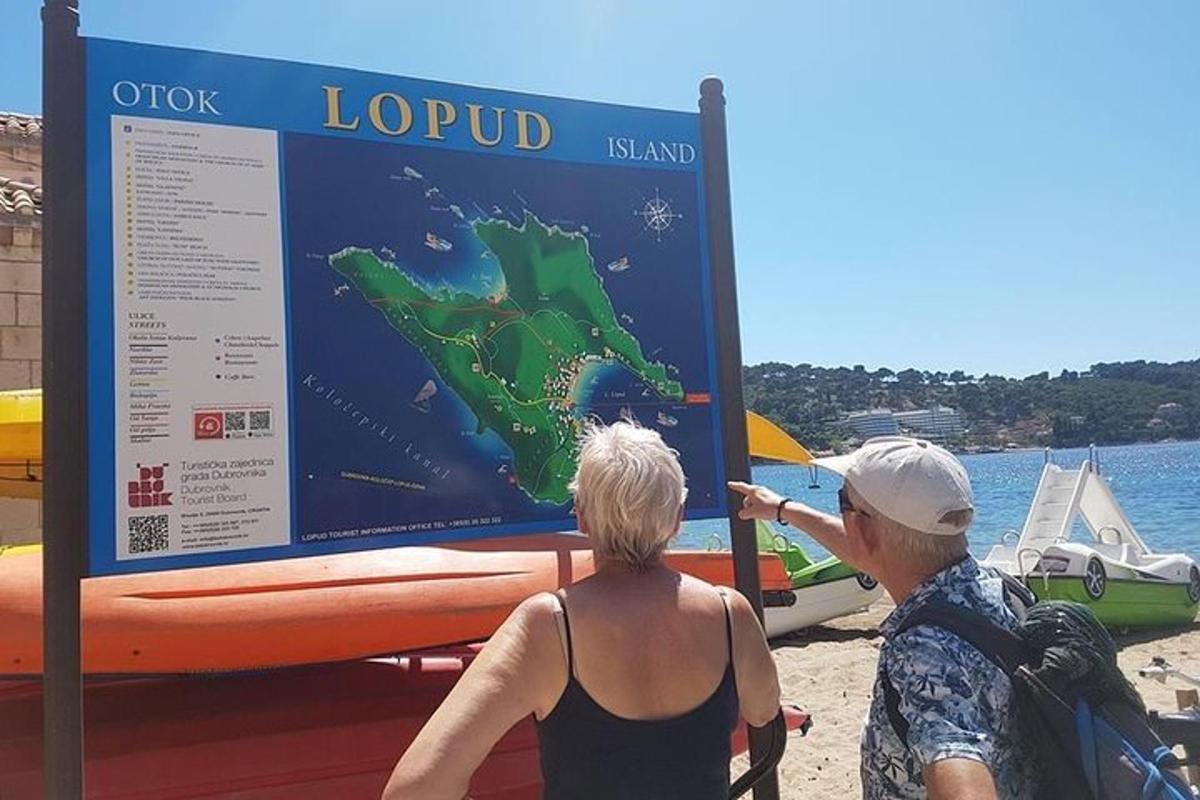 Dos mujeres paradas en la playa mirando un cartel