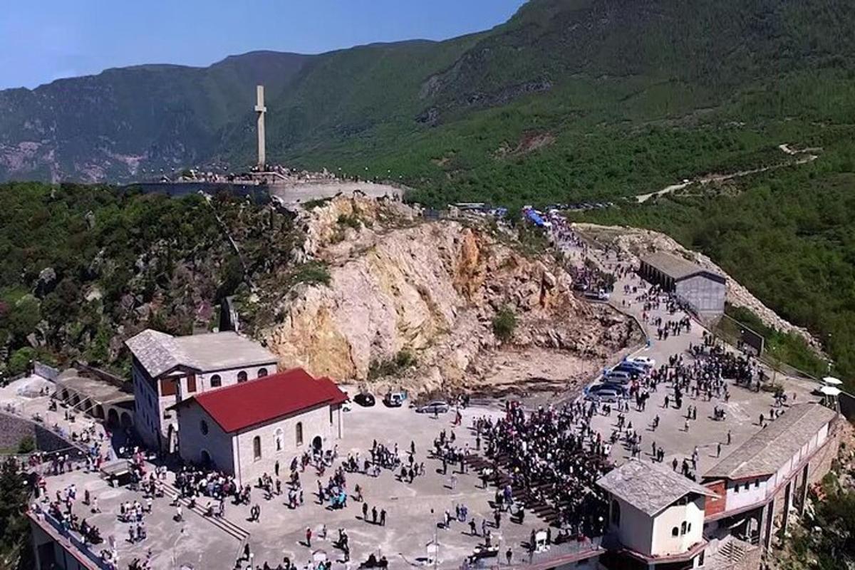 un gruppo di persone radunate attorno a una chiesa su una montagna