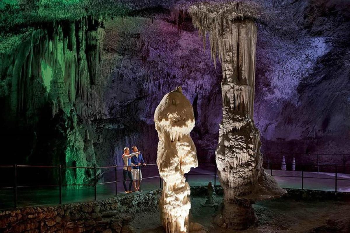 two people standing in front of a cave