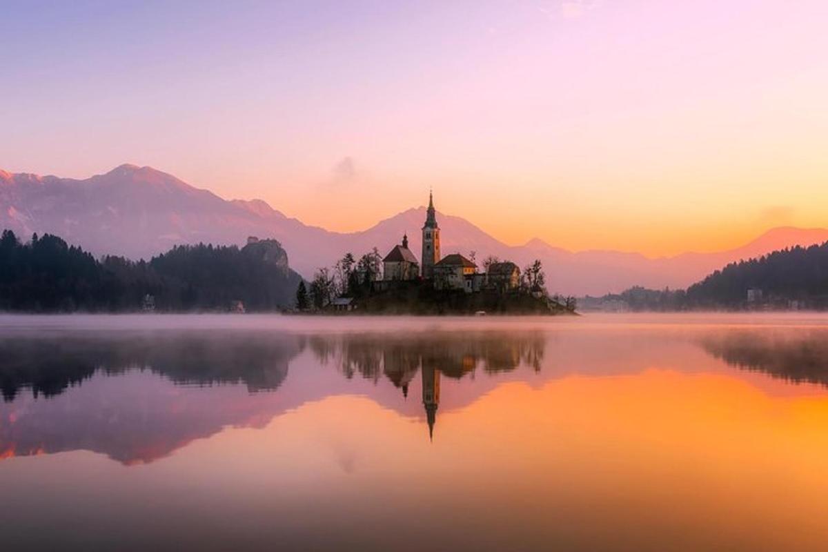 an island in the middle of a lake at sunset