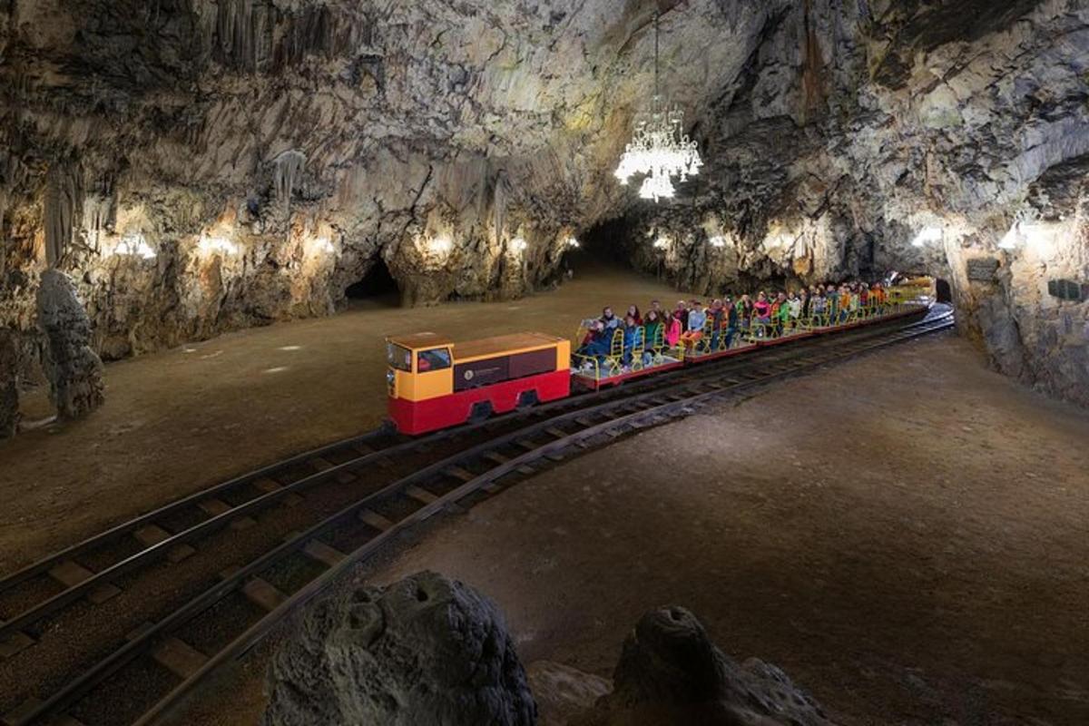 Un pequeño tren en una cueva con gente en él.