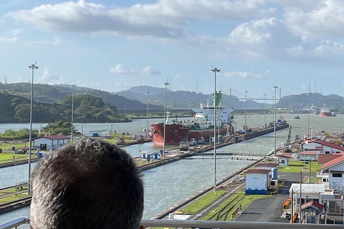 a person looking out of a window at a ship in the water