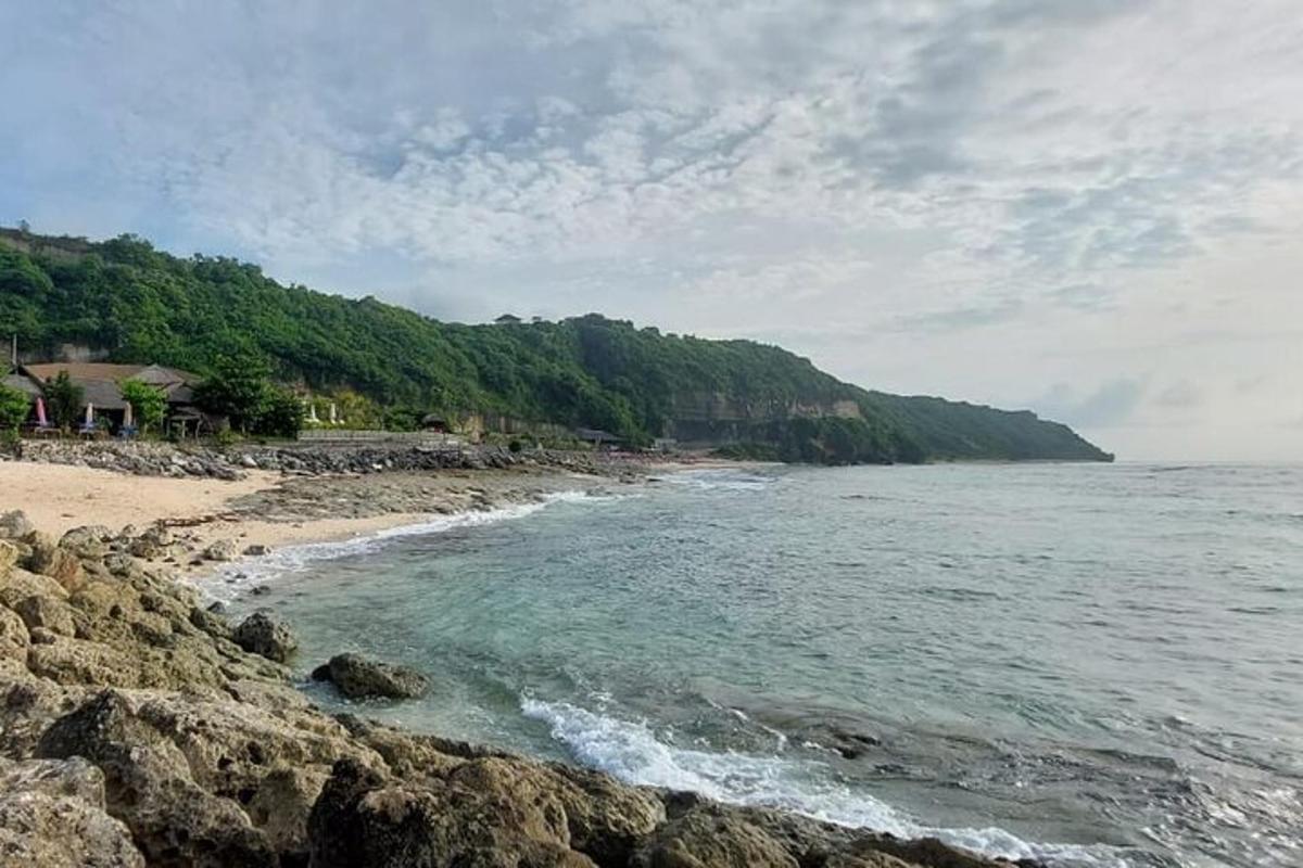 Una playa con rocas y el océano en un día nublado.