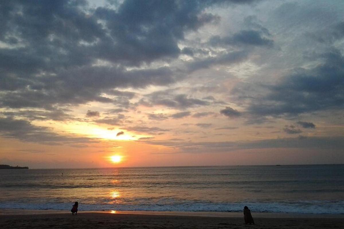 ビーチに立つ人とビーチの夕日