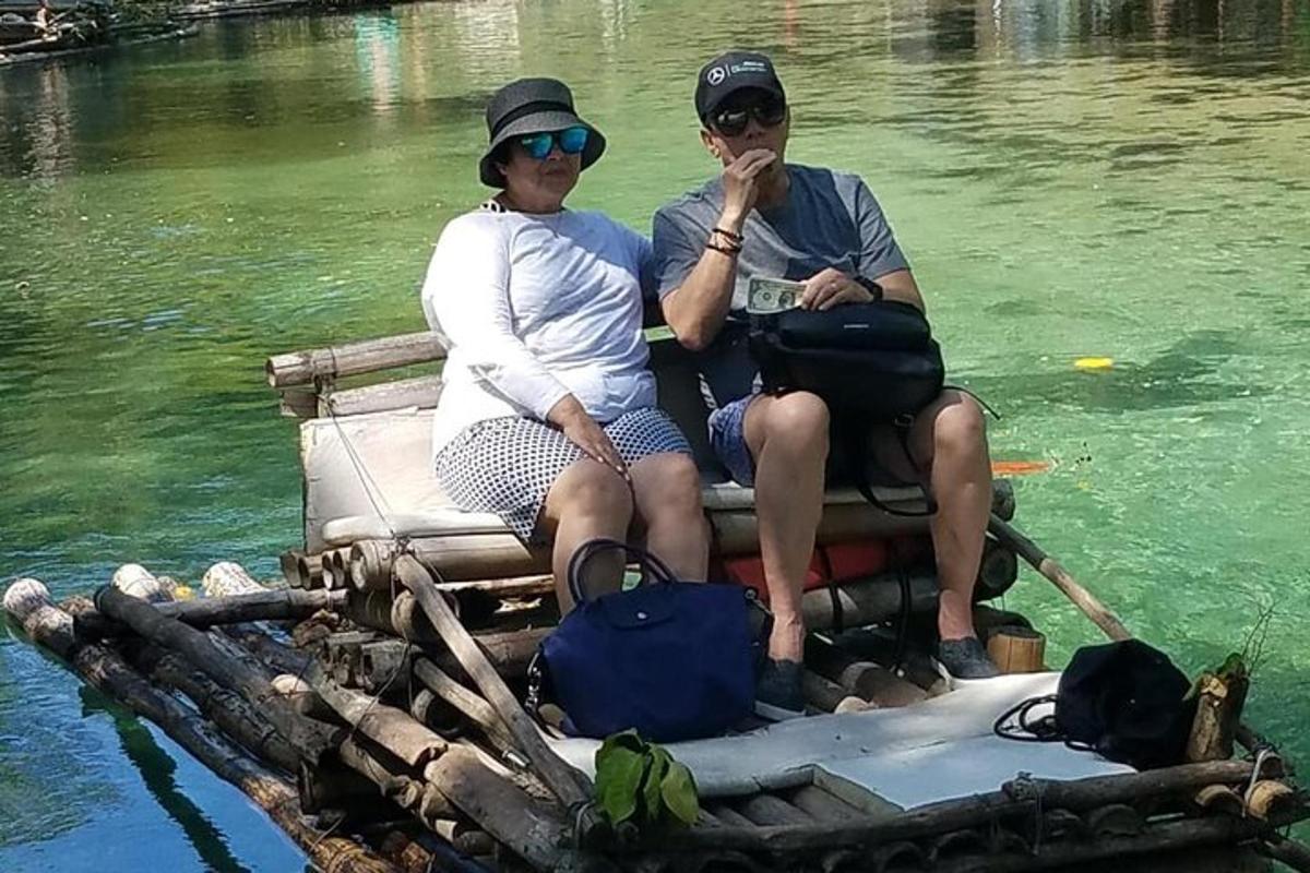 dva lidé sedící na zadní straně voru ve vodě