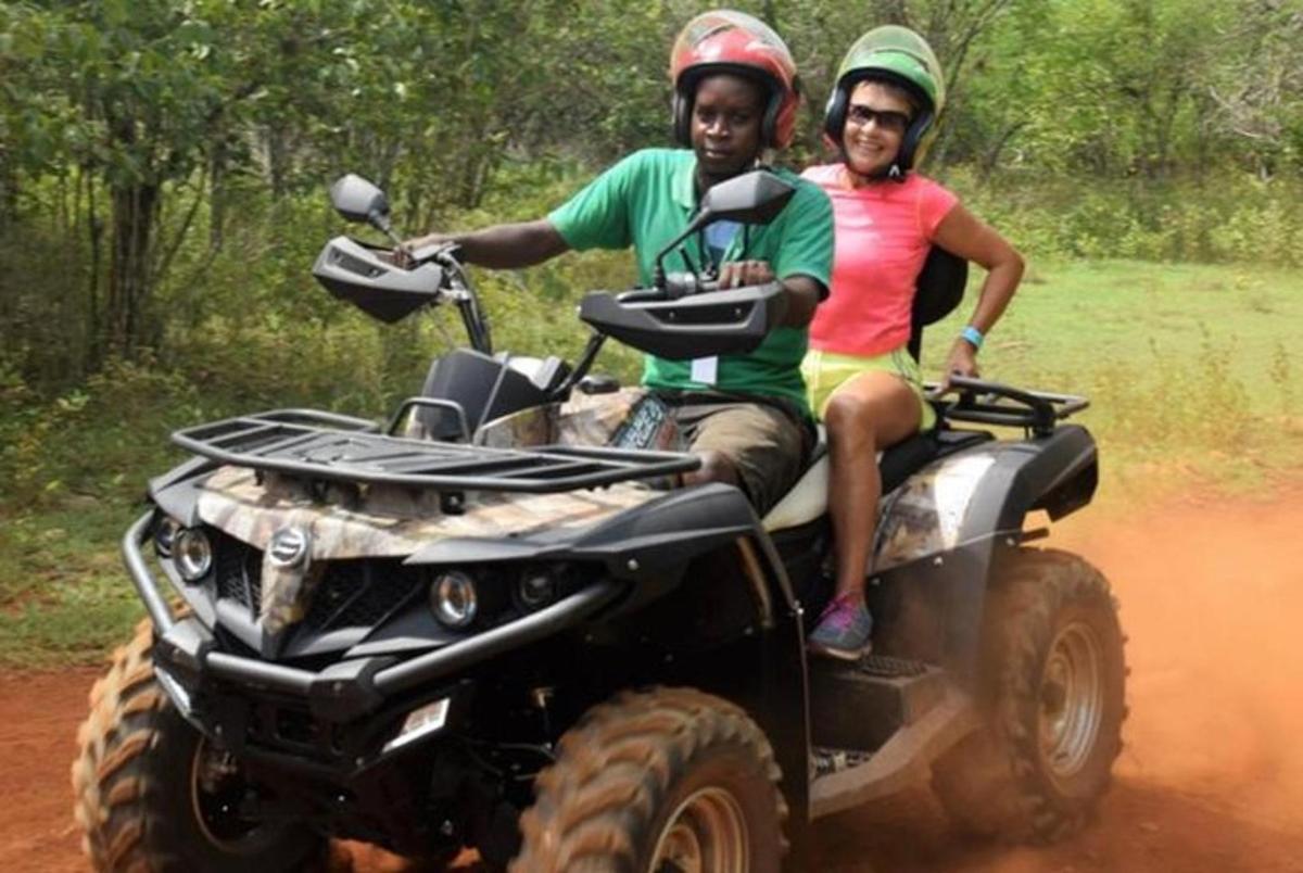 dos homes que viatgen en un quad per una carretera de terra