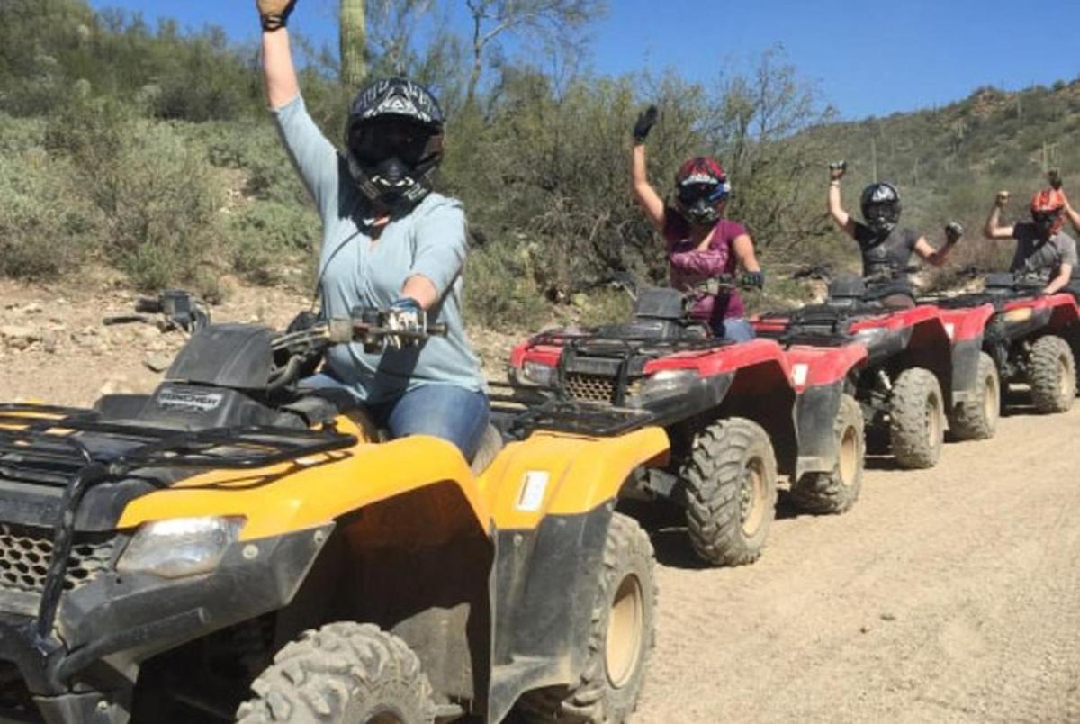 un grup de persones que condueixen quads per un camí de terra