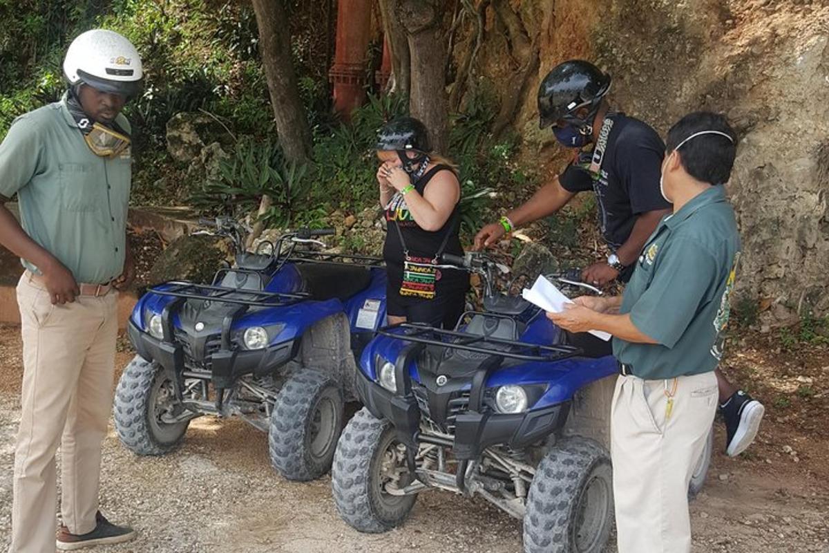 un grup de persones al costat de dos quads