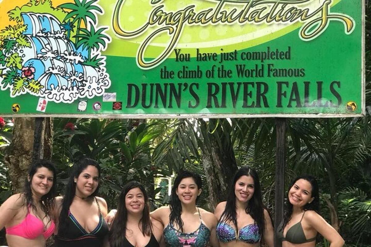 um grupo de garotas em trajes de banho em frente a uma placa