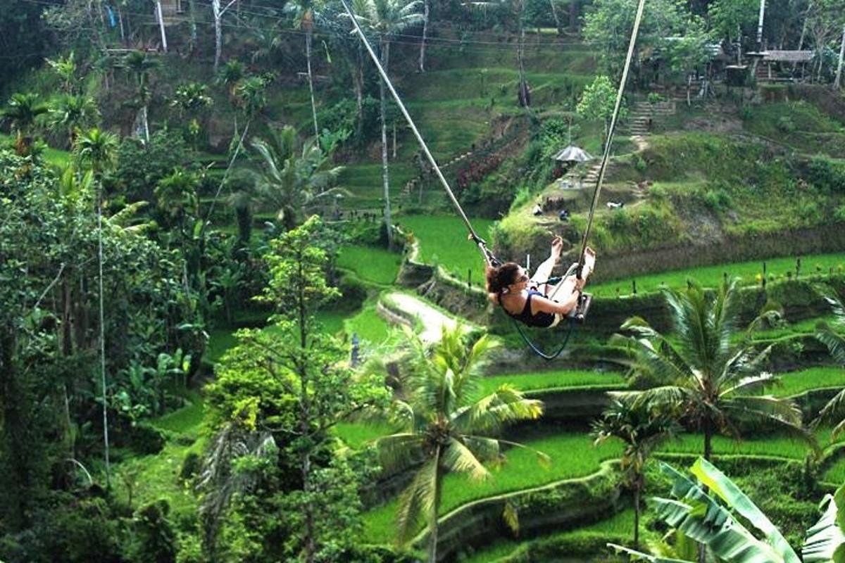 a woman swinging on a zip line in the jungle
