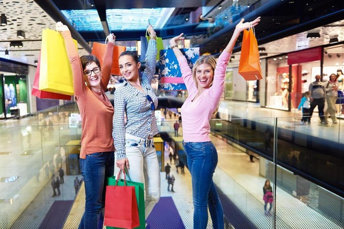 three women holding shopping bags in a shopping mall